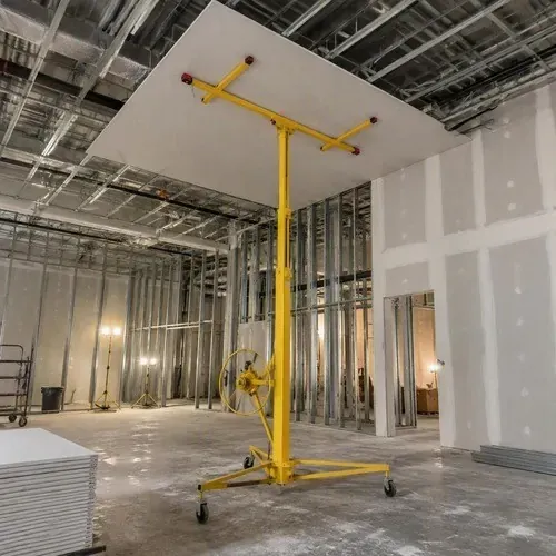 Drywall lift holding a sheet to a high ceiling on a larger project in the Belleville area