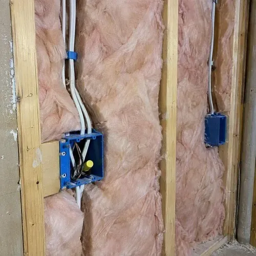 Insulation cut neatly around electrical wiring during insulation and drywall work in Kingston, ON