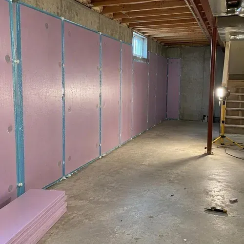 Rigid foam boards against basement foundation wall during insulation and drywall work in Kingston, ON