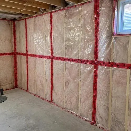Taped vapour barrier seams in a basement during insulation and drywall work in Kingston, ON