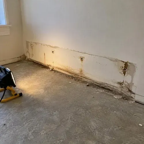 Wall damage behind a removed baseboard heater on a drywall repair job in Kingston, ON