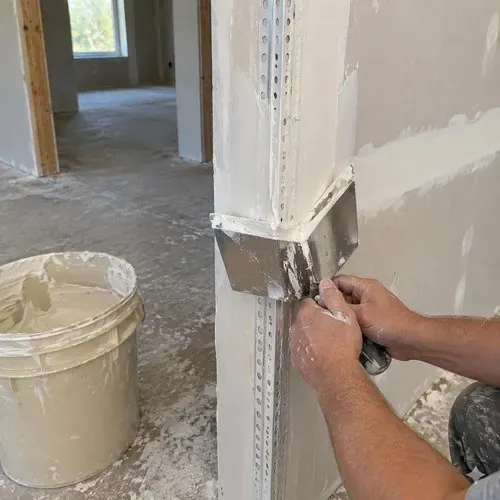 Corner bead mudded with a corner knife during drywall taping and finishing in Kingston, ON