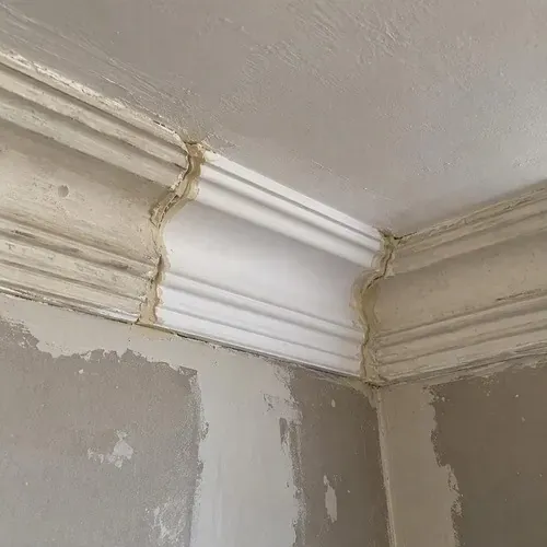 Newly cast moulding section fitted into run during plaster crown moulding repair in Kingston, ON