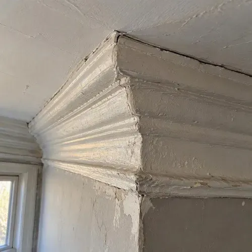 Plaster cornice with paint buildup and lost detail during plaster crown moulding repair in Kingston, ON