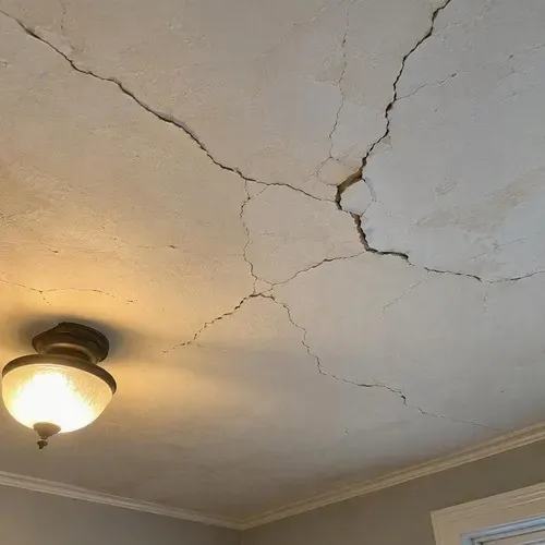 Hairline cracks spidering across old plaster ceiling during lath and plaster repair in a Kingston home