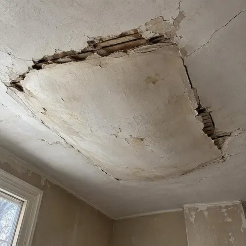 Loose plaster bulging away from a ceiling during lath and plaster repair in a Kingston home