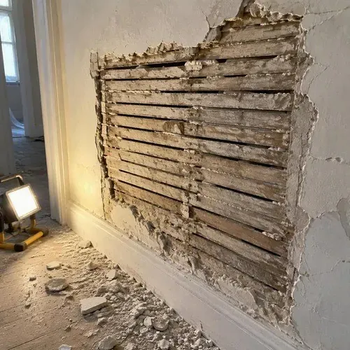 Plaster keyed back onto wood lath during lath and plaster repair in a Kingston home