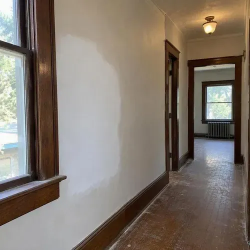 Repaired plaster wall in century home hallway during lath and plaster repair in a Kingston home