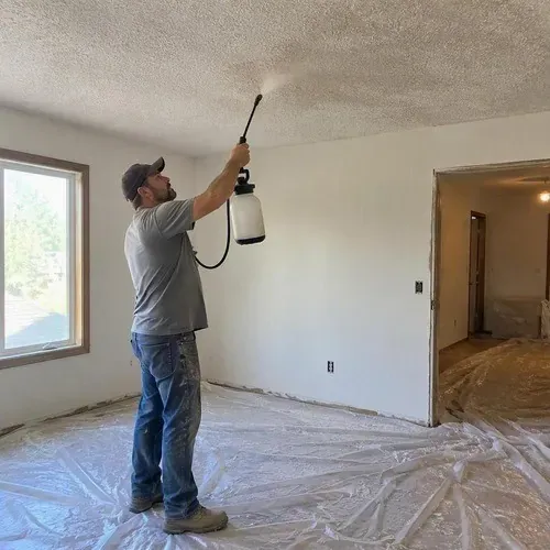 Popcorn ceiling sprayed with water before scraping during popcorn ceiling removal in Kingston, ON