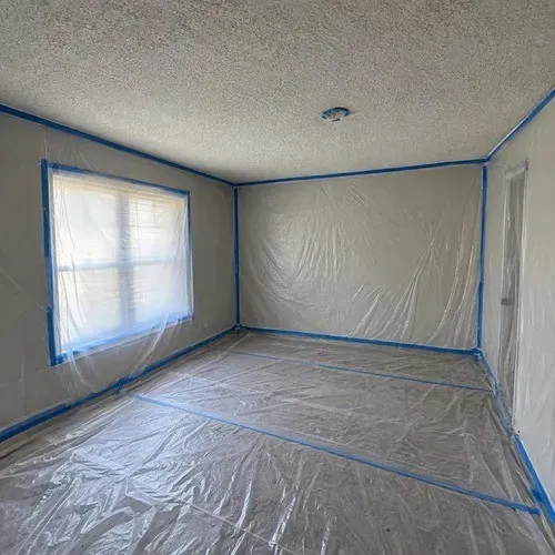 Room fully masked in plastic before texture removal during popcorn ceiling removal in Kingston, ON