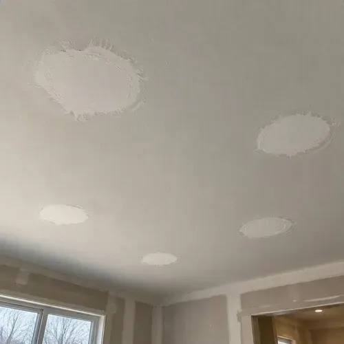 Mudded pot light patches drying on ceiling during pot light hole repair in Kingston, ON