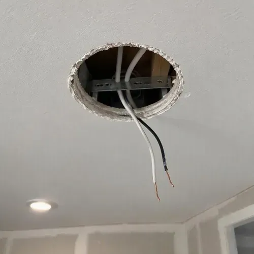 Round pot light hole with wiring hanging during pot light hole repair in Kingston, ON