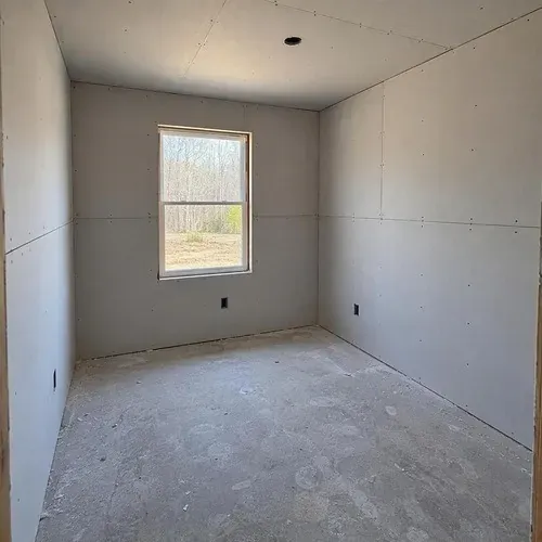 Bedroom fully hung with drywall before taping on a residential drywall installation in Kingston, ON
