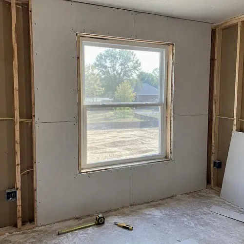 Drywall cut around a new living room window on a residential drywall installation in Kingston, ON