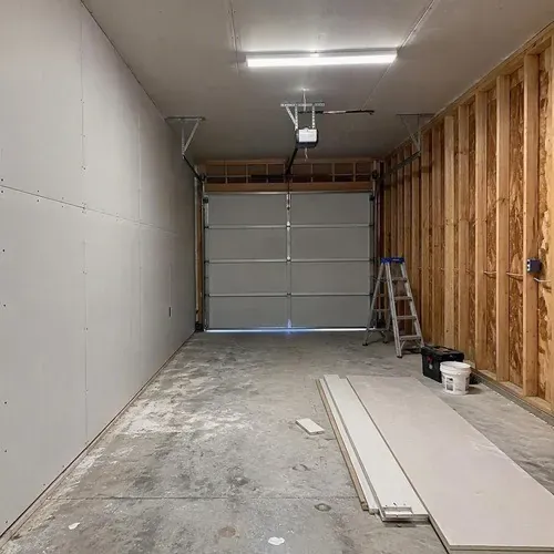 Garage half drywalled with studs still exposed on a residential drywall installation in Kingston, ON