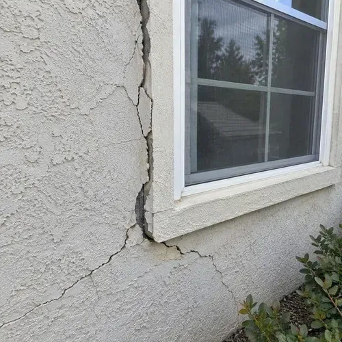 Stucco cracked around an exterior window frame on a stucco repair job in the Kingston area