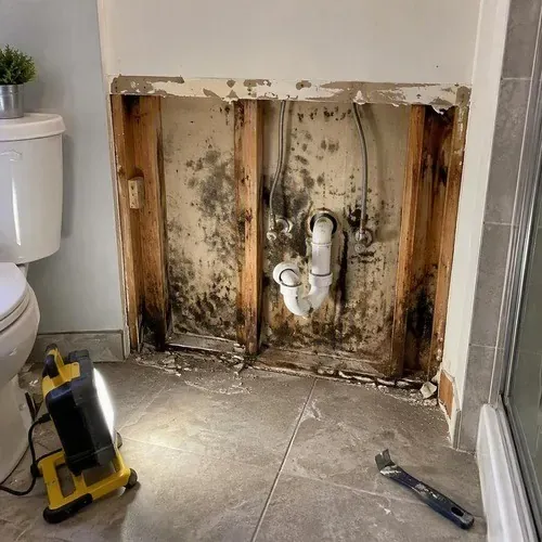 Mouldy drywall behind a removed bathroom vanity during water damage drywall repair in Kingston, ON